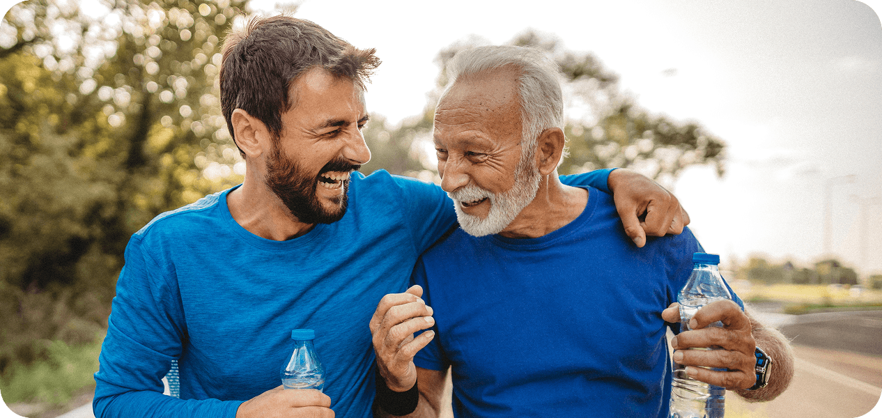 A son with his arm around his father, both smiling